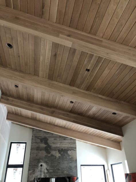 White Oak Tongue and Groove with White Oak beam wraps. Outdoor Vaulted Wood Ceiling, Tongue And Groove Ceiling Dining Room, Tongue And Groove With Beams, Interior Beam Stain Colors, Oak Tongue And Groove Ceiling, Tongue And Groove Deck Ceiling, Tongue And Groove Living Room Ceiling, White Oak Paneled Walls, Vaulted Ceiling Tongue And Groove