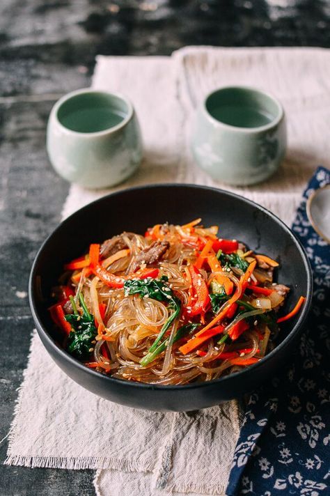 Japchae is a simple Korean noodle dish jampacked with a rainbow of vegetables and accented with a hit of flank steak. It’s a recipe that’s been requested by many of our readers, so this day is long overdue! Japchae is made with Korean potato starch glass noodles, which are surprisingly light, and (it doesn’t happen often … Glass Noodle Stir Fry, Japchae Recipe, Korean Noodle Dishes, Recipes Korean, Korean Glass Noodles, Easy Korean Recipes, Noodle Stir Fry, Korean Noodles, Woks Of Life