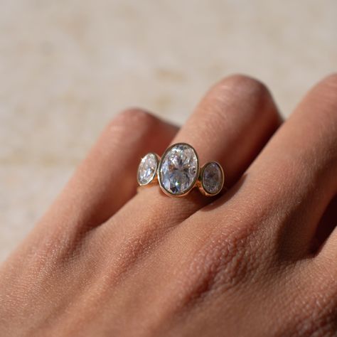 This alternative style three stone oval engagement ring features a full bezel setting for each stone, lifted onto the finger for a grand finish. Sublime 🤍 Details: - 2ct oval moissanite centre - 2x 0.4ct oval moissanite accent stones - 18k yellow gold - 2mm wide shank #engagementringdesign #customengagementring #bespokeengagementring #threestoneengagementring #moissaniteengagementring #nz #aus Bezel Three Stone Engagement Ring, Three Stone Bezel Set Ring, Three Stone Oval Engagement Ring, Oval Engagement Ring, Bezel Engagement Ring, Bespoke Engagement Ring, Bezel Set Ring, Oval Engagement, Oval Moissanite