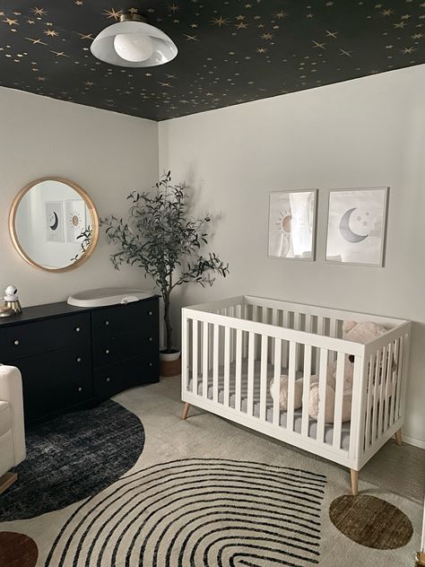 My baby boy’s little dreamer nursery! 💫🌠☁️🌑☀️ moody, modern, sophisticated and playful nursery interior design. Ceiling wallpaper, moon themed light fixture, abstract area rug and more linked on LTK!

Interior Designer: Homes by Simmone Gold And Black Nursery, Moon Themed Bedroom, Moody Baby Nursery, Monochromatic Nursery, Contemporary Baby Nursery, Interior Design Ceiling, Playful Nursery, Night Sky Nursery, White Kids Room