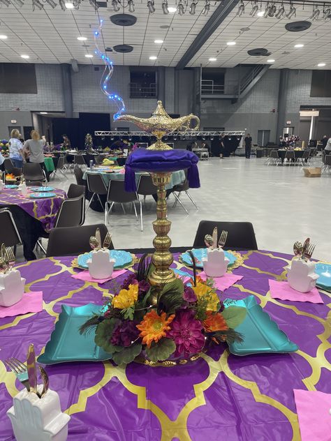 Created with satin pillows and foam carved to pillow shapes, blue LED lights on a silver wire, brass lamp, brass candlestick and silk flowers on a gold metallic plastic tray. I also added warm white LEDs to the flowers. This was for a Mardi Gras event. Got lots of nice compliments. Arabian Nights Quinceanera Theme, Arabian Nights Prom Theme, Arabian Nights Dance Theme, Aladdin Centerpiece Ideas, Arabian Nights Diy Decorations, Arabian Nights Centerpieces, Arabian Centerpieces, Arabian Nights Party Decorations, Arabian Nights Homecoming