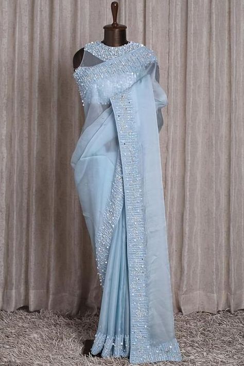 A dream-like ensemble fashioned from Organza feels light and airy. The translucent Powder Blue body displays stone details flaunts a sparkling sequins, pearl and stone embroidered border is styled with a matching pre-stitched net blouse, constructed with illusion neckline and sleeveless. Saree Everyday, Powder Blue Saree, Light Blue Saree, Plain Saree With Heavy Blouse, Drape Sarees, Net Blouse, Saree Wearing Styles, Wedding Lehenga Designs, Traditional Blouse Designs