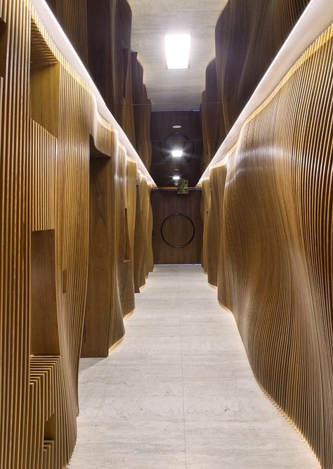 Fernanda Marques Arquitetos Associados has designed an apartment in Miami, Florida, and as part of the design, they included an eye-catching sculptural wood hallway with a mirrored ceiling. #WoodHallway #SculpturalHallway #WavyWoodWall #InteriorDesign #MirroredCeiling Wood Hallway, Apartment In Miami, Miami Interiors, Hidden Lighting, Mirror Ceiling, Restroom Design, Tinted Mirror, Houses In France, Corridor Lighting