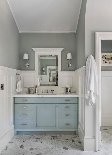 Gray marble herringbone floor tiles lead to a blue washstand adorned with nickel pulls and a white marble countertop fitted with a polished nickel cross handle faucet. Blue Vanity, Painted Vanity, House Of Turquoise, Small Bathroom Vanities, Bathroom Paint Colors, Transitional Bathroom, Blue Cabinets, Subway Tiles, Blue Bathroom