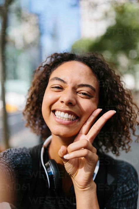 Cheerful woman showing peace sign in city – Stockphoto Double Peace Sign Pose Reference, Upside Down Peace Sign Pose, Peace Sign Pose Reference Photo, Peace Sign Reference, Person Doing Peace Sign Reference, Female Peace Sign Pose, Peace Sign Pose Reference, Peace Sign Pose, Hand Poses Peace Sign