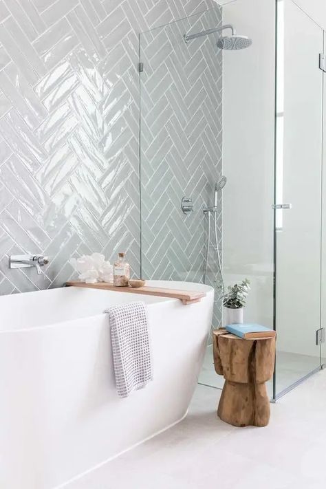 A serene contemporary bathroom clad with grey herringbone tiles, an oval tub, a shower space and a cork stool Medium Bathroom Ideas, Small Bathroom Modern, Herringbone Tile Bathroom, Cheap Bathroom Remodel, Bathroom Furniture Modern, Cheap Bathrooms, Interior Minimalista, Bathroom Tub, Classic Bathroom