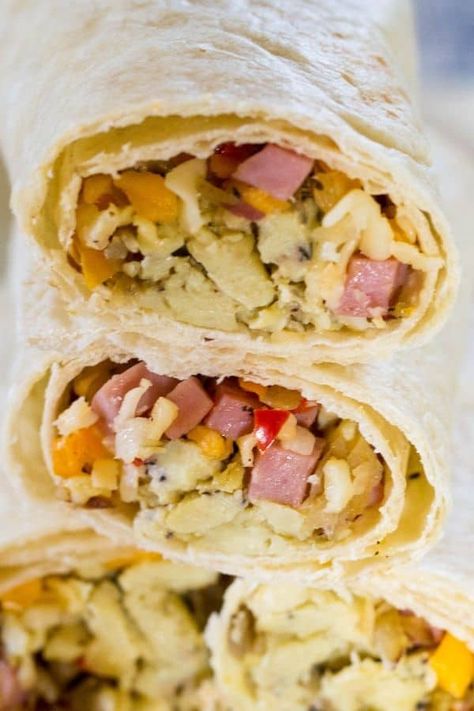 Delicious make ahead ham and egg burritos stacked up and ready to be eaten. Ham And Egg Breakfast Burrito, Ham And Egg Burrito, Ham Breakfast Burritos, Make Ahead Ham, Egg Burritos, Veggie Egg Scramble, Egg Burrito, Postpartum Meal, Make Ahead Breakfast Burritos