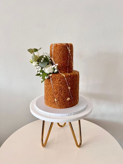 Two tier Russian Honey cake on a white and gold cake stand. Decorated with white buttercream splattering, edible gold leaf and flowers Medovik Cake Decoration, Honey Cake Decoration, Medovik Cake, Russian Honey Cake, Bakery London, Russian Desserts, 7 Cake, 70th Birthday Cake, Edible Gold Leaf