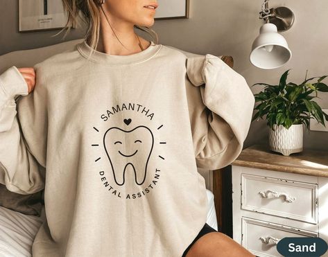 Are you looking for a custom gift for your dental office team? These personalized dental tooth shirts are perfect for any dental office staff, dental assistant, dental student, dental hygienist, dental receptionist, dental lab tech or dentist. Or add your own custom job title.  Our unisex dental professional crewneck sweatshirts are made from high quality materials and are light and well fitted, and designed to keep you warm and comfortable while you work if the office is a bit chilly.  Plus, th Dental Receptionist, Dental Ideas, Dental Branding, Dental Assistant Shirts, Diy Vinyl Projects, Dental Tips, Office Shirts, Dental Assistant Gifts, Dental Shirts