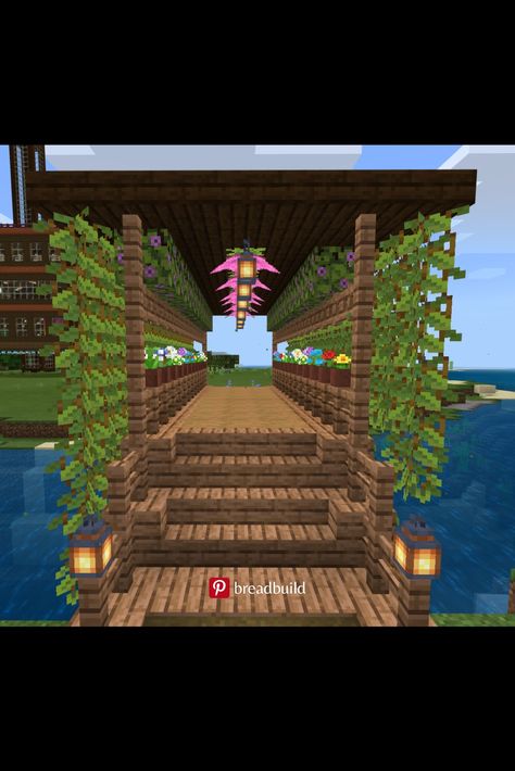 This Minecraft bridge is made of wood and lots of plants. This is after the Minecraft 1.17 Cave Update, Glow Berry and Spore Blossom were added. Spore Blossom In Minecraft, Minecraft Glow Berries Ideas, Cherry Blossom Wood Minecraft, Minecraft Glow Berries Farm, Minecraft Cherry Blossom Bridge, Cherry Blossom Bridge Minecraft, Minecraft Cherry Blossom, Flower Archway, Minecraft Bridge