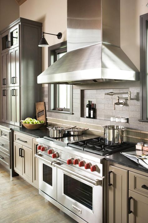 A small niche behind the stove is a great place for oils and spices, and a faucet above the stove is ideal for filling large pots. A mix of grays and browns makes this high-end, custom kitchen feel earthy and natural. Contemporary Mountain Home, Casa Cook, Efficient Kitchen, White Kitchen Remodeling, Eclectic Kitchen, Paris Home, Pot Filler, Kitchen Stove, Vogue Covers