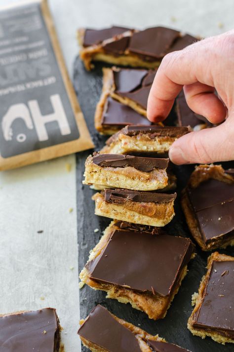 It's that time of year again- Halloween candy recipes! Try this easy, healthy raw vegan “Twix” bars with an almond flour base, date caramel center, and dark chocolate topping. Gluten-free, vegan, and refined sugar-free. | Dessert Recipes | Flora & Vino | Vegan Twix Bars, Desserts With Dates, Nougat Bars, Halloween Candy Recipes, Millionaire's Shortbread, Twix Bars, Date Caramel, Healthy Candy, Raw Vegan Desserts