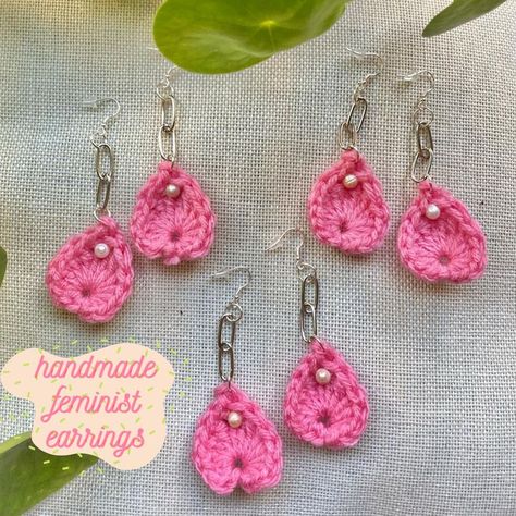 This photo features 3 pairs of handmade feminist earrings. The main part is crocheted with pink yarn to look like flower petals, the pleasure points are fresh water pearls, and they're attached to stainless steel ear hooks with two stylish chain links. The earrings are laying on a rough, off white pillow with a few piles plant leaves peeking in from the right and top. Feminist Crochet, Feminist Earrings, Crocheted Flower, Crochet Jewelry Patterns, Reno Nevada, Jewelry Clothes, Crochet Shop, Crochet Inspo, Crochet Inspiration