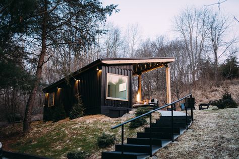 "The shipping container was placed on a cinder-block crawl space, which contains the furnace, the plumbing, and a tankless hot-water heater," Dianna says. Unique Cabin, Logan Ohio, Zelt Camping, Shipping Container Cabin, Tiny Houses For Rent, Container Cabin, Glass Garage Door, Fire Pit Seating, Metal Siding