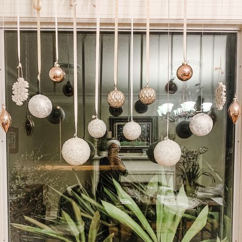 Ornaments Hanging From Window, Ornaments On Window, Christmas Ornament Window Display, Christmas Bauble Window Display, Christmas Decoration For Windows, Christmas Balls Hanging From Window, Christmas Balls Window Display, Christmas Ornament Window Decorations, Window Ornaments Ideas