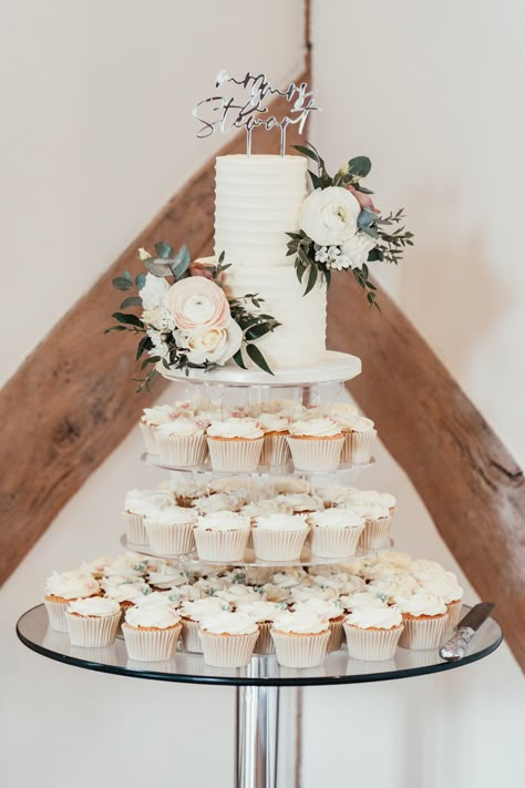 Elegant buttercream 2 tier wedding cake with fresh flowers and surrounded by wedding cupcakes. Wedding in Hampshire at Cain Manor. Two Tiered Wedding Cake With Cupcakes, Single Layer Wedding Cake With Cupcakes, Tall Single Tier Wedding Cake, 2 Tier Wedding Cake With Cupcakes, Cupcake Tier Cake, Wedding Cake Two Tier, 2 Tier Wedding Cake, Cain Manor, Wedding Cake With Fresh Flowers