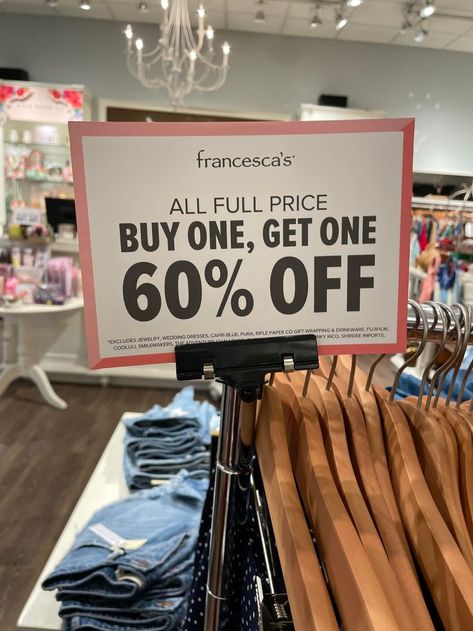 This image of a sign attatched above a clothing rack is another example of promotional signage within a Francesca's store. This sign is promoting the sales of their full-priced merchandise by offering a buy one get one 60% off sale within the store. This sign was also found in other various locations around the shop, mostly above or around full priced merchandise. Capri Blue, Buy One Get One, Visual Merchandising, A Sign, Clothing Rack, Off Sale, Get One, Promotion, Novelty Sign