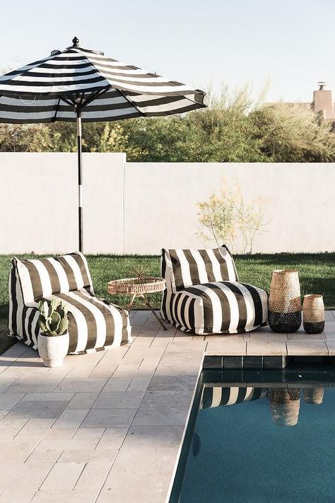 Black and white stripe slipper plush pool chairs add the perfect lounging finish to a backyard pool joined with a matching outdoor umbrella and a woven accent table. Around The Pool Ideas, White Pool, Pool Lounge Chairs, Pool Umbrellas, Pool Chairs, Cozy Patio, Backyard Furniture, Pool Lounge, Patio Lounge Chairs