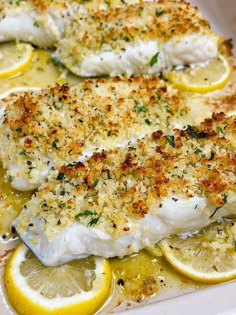 easy lemon garlic baked halibut recipe hero image close up cooked with crispy topping on a bed of lemon Lemon Caper Halibut, Halibut Salad Recipes, Crusted Halibut Recipes Baked, Petrale Sole Recipes Baked, Baked Halibut Recipes Parmesan Crusted, Best Halibut Recipes Baked, Lemon Halibut Recipes, Lemon Dill Cod, Baked Pickerel Recipes