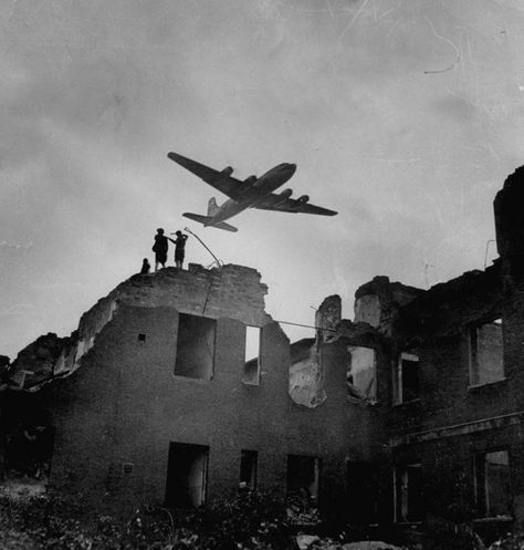 Civilians atop bombed out ruins of buildings watching American C-54 cargo plane fly overhead during Allied Berlin airlift to bring food & supplies to beseiged citizens of Soviet controlled Berlin. Photo: CHARLES FENNO JACOBS, Getty Images / Time & Life Pictures Creative Berlin Airlift, Spaces Photography, Random Reference, Colorized Photos, Black And White Photograph, Time Life, Blue Marble, Jolie Photo, D Day