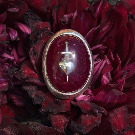 As a wise man once said, grief is the price we pay for love... The Sword-Pierced Heart ring is a brand-new addition to the world of Medieval-inspired works by Alex Streeter. This bold yet sophisticated ring is available in Black and Crushed Ruby - perfect for both men and women looking to add a unique statement piece to their collection. Ruby has long been considered a talisman of love and was a once a very popular choice for engagement rings.This motif was originally inspired by medieval portra Vampire Ring, Medieval Rings, Unique Mens Rings, Edgy Jewelry, Wise Man, Witch Aesthetic, Wedding Rings Unique, Silver Accessories, Wedding Board