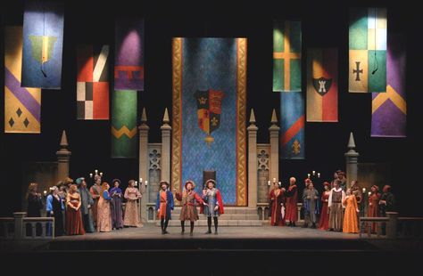 King Hildebrandt's throne room, and in the center of the room are his son, Prince Hilarion, and Hilarions friends, Florian and Cyrill.  This is a beautiful production with stage sets that remind me greatly of Disney's Sleeping Beauty. Keepers Of The Kingdom, Kingdom Vbs, The King Is Coming, Pilgrim Costume, Theater Lighting, King On Throne, Rei Arthur, Once Upon A Mattress, Armor Medieval