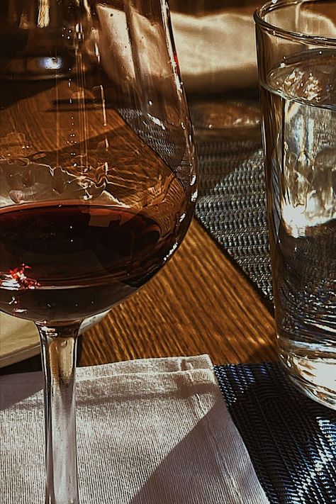 A wine glass with red wine and a glass with water and sunlight shining through both of them stand side by side on a wood dining table. Industrial Modern Interior, Twisted Emotions, Glass With Water, Most Beautiful Restaurants, Wine Restaurant, Beautiful Restaurants, Wine Aesthetic, Silver Oak, Cora Reilly