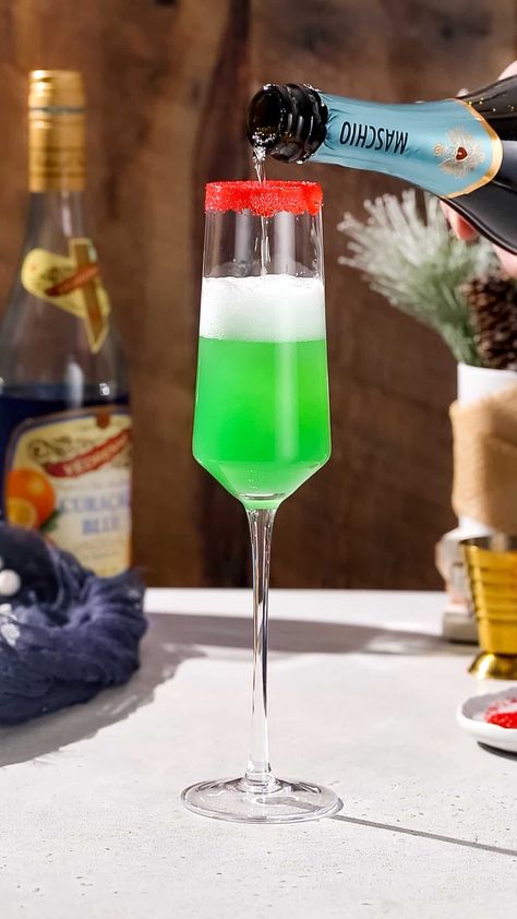 This Grinch Mimosa cocktail is an easy and festive champagne cocktail for Christmas! This fizzy green drink with a red sugar rim is perfect for the holiday season. This drink features pineapple juice instead of orange juice, and a touch of Blue Curaçao liqueur to give it a vibrant green color and a little extra flavor. Perfect for your Christmas cocktail menu! Green Grinch Mimosa, Grinch Mimosa Recipe, Grinch Mimosa, Grinch Drink, Blue Curacao Liqueur, Mimosa Cocktail, Drink Recipies, Green Drink, Red Sugar