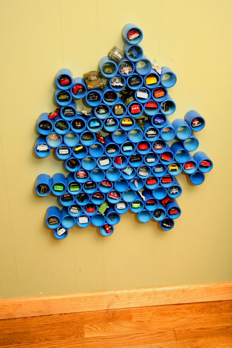 Cool Hot Wheels or Matchbox car collection holder!  1-1/2" diameter pvc pipe dyed blue and glued together with pvc solvent. cut back of pipes at a slight angle so the cars don't roll out.  Glue them together in any random beehive pattern and hang it on the wall at kid height.  They have as much fun putting the cars in and out of the slots as they do playing with the cars. Pvc Pipe Storage, Littlest Pet Shops, Hot Wheels Storage, Pvc Projects, Artsy Design, Toy Rooms, Big Boy Room, Hot Wheels Cars, Pvc Pipe