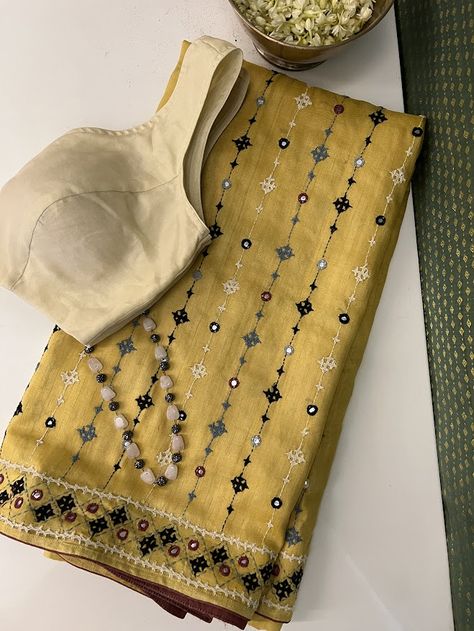 A handwoven mustard saree with with black beige and grey combination of kutch work all over the saree. The border and body of the saree has mirror work like detailing . The saree comes with a self blouse piece with work on sleeves Kutch Work Dress Designs, Work Wear Saree, New Dress Design Indian, Kutch Work Saree, Mustard Saree, Mirror Work Saree Blouse, Mirror Work Border, Work On Sleeves, Textile Designing