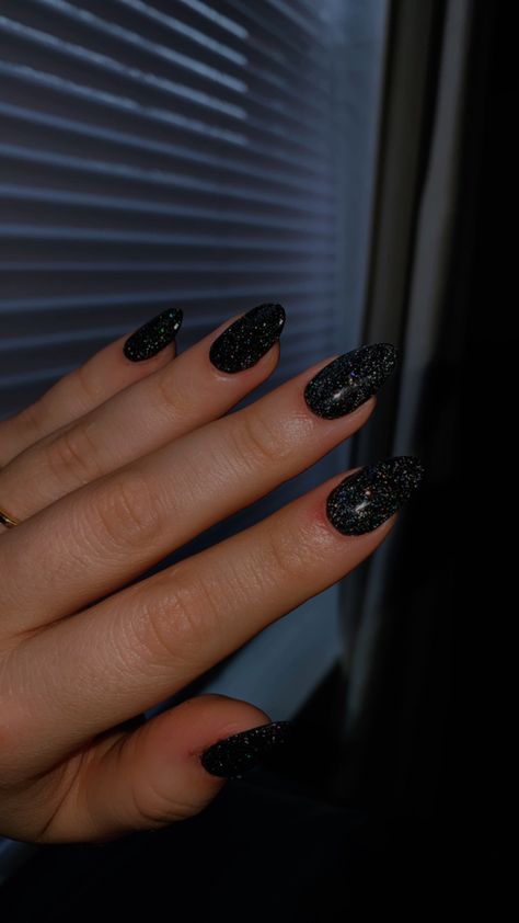 This is a dip nail with tips. The shape is almond, and my tech did 2 dips of plain black and 1 dip of sparkle black. Short Black Sparkly Nails, Short Almond Acrylic Nails Black Sparkle, Black Sparkly Nails Almond, Black Nails With Glitter Almond Shape, Black Sparkle Nails Almond, Black Almond Nails Designs Glitter, Glittery Black Nails Short, Black Glitter Dip Nails, Black Sparkle Dip Powder Nails