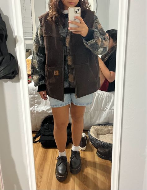 mirror picture. brown carhartt best. grandpa sweater. doc martnes. jorts Carhart Vest Girl Outfit, How To Style A Sweater Vest Fall, Outfits With Carhartt Vest, Carhartt Women Outfits Fall, Carhartt Gilet Outfit, How To Style Brown Doc Martens, Women’s Carhartt Vest Outfit, Brown Sherpa Vest Outfit, Carhartt Outfit Aesthetic