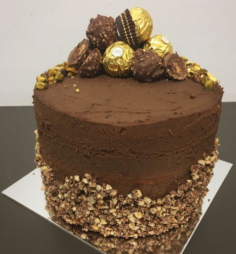 Ferrero Rocher Cake - hazelnut sponge, choc mousse and Ferrero Rocher truffles.   Check out https://everylastcrumbcakery.com/ for more info on this and other cakes. Mika xx Ferrorocher Cakes, White Ferrero Rocher Cake, Birthday Cake With Ferrero Rocher, Vegan Ferrero Rocher Cake, Chocolate Cake Ferrero Rocher, Choc Mousse, Ferrero Rocher Cake, Box Cake, Bento Box