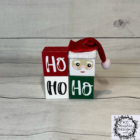 "These HO HO HO Santa inspired wood blocks will add a nice touch to your Christmas decor. They will also look cute standing alone or in your tier tray!  The blocks are hand painted. They are then sanded to achieve that rustic state. I then affixed high quality vinyl for all wording and designs. They are sprayed with a sealant for longevity.  My items are all handmade, no two pieces are alike. Each piece has its own natural imperfections which make them unique.  The blocks standing on each other Tier Tray Wood Blocks, Christmas Scrap Wood Crafts, Christmas Wood Blocks Diy, Wood Block Crafts Christmas, Christmas Blocks Wooden Diy, 4x4 Christmas Wood Crafts, Wooden Cube Crafts, Wooden Blocks Decor Craft Ideas, Christmas Craft Fair Ideas To Sell