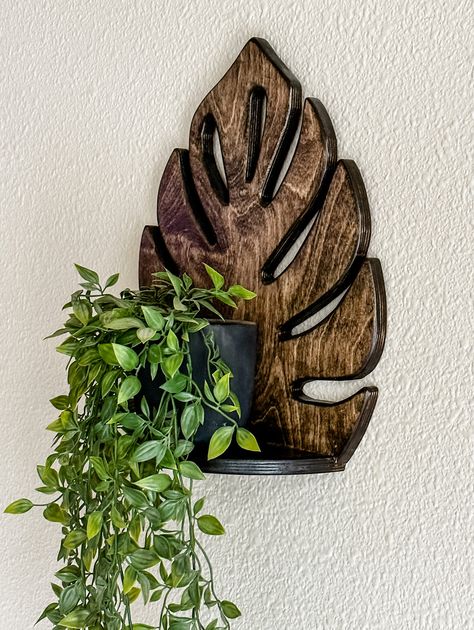 This leaf design adds the minimalistic charm your home needs. This shelf was handcrafted from baltic birch, a renewable resource. It comes with keyhole hangers. It is the perfect display for any greenery.Dimensions are: Style shelf Finish dark brown stain Tray dimensions 16 inches tall12.5 inches wide usable shelf 4.25 Monstera Bathroom Decor, Monstera Shelf, Leaf Shelf, Keyhole Hangers, Dark Bohemian, Wall Hanging Decorations, Style Shelf, Laundry Hampers, Hanging Plant Wall