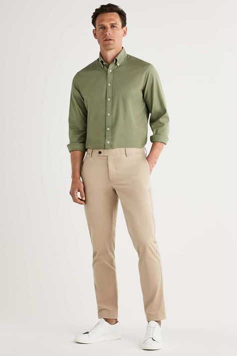 Men's khaki pants, green Oxford shirt and white sneakers outfit. This outfit first appeared in the article: What Colours To Wear With Khaki Pants: 6 Foolproof Shirt Options, on MensFlair.com Green Shirt Khaki Pants Outfit Men, Green Shirt Beige Pants Outfit, Green Shirt Beige Pants Men, Khaki Formal Outfit For Men, White Shirt Green Pants Men, Light Green Polo Shirt Outfit Men, Olive Green Polo Shirt Outfit Men, Beige Khaki Pants Outfit Men, Green White Outfit Men