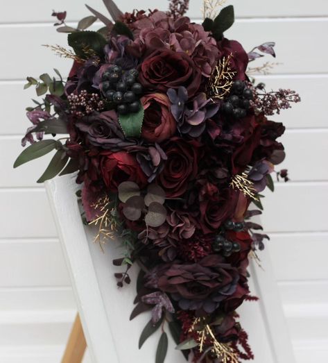 Embrace the allure of romance with this captivating cascading bouquet. Rich burgundy roses and delicate hydrangeas blend seamlessly with lush foliage and hints of gold, creating an elegant and dramatic statement piece for your special day. Perfect for brides seeking a touch of vintage glamour and timeless sophistication. 💍✨ #CascadingBouquet #WeddingFlowers #BridalBouquet #burgundywedding #cascadingflowers #darkwedding #weddindflorist #WeddingBouquets #weddingvendor Wedding Bouquets Dark, Burgundy Roses, Cascading Bouquet, Cascading Flowers, Castle Aesthetic, Dark Wedding, Cascade Bouquet, Dark Rose, Rich Burgundy