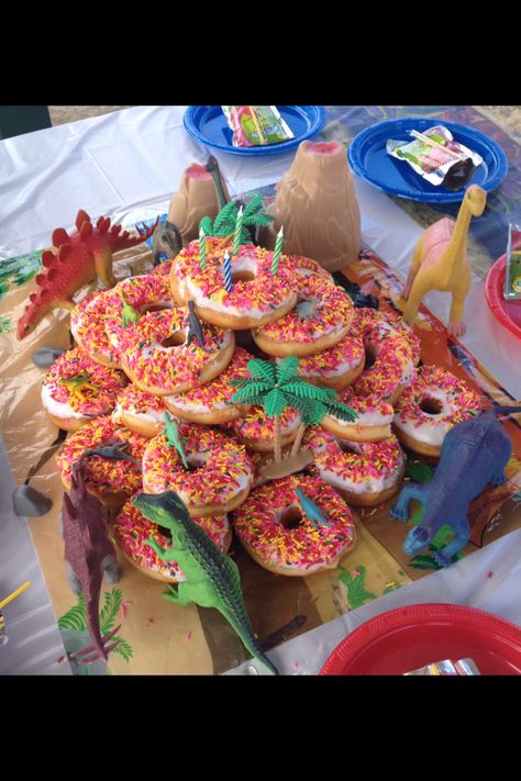 Super easy and fun dinosaur donut birthday "cake" Birthday Cake Dinosaur, Donut Birthday Cake, Girl Dinosaur Birthday, Dinosaur Themed Birthday Party, Donut Birthday Parties, Donut Birthday, Dino Birthday Party, Dinosaur Theme Party, Dinosaur Cake