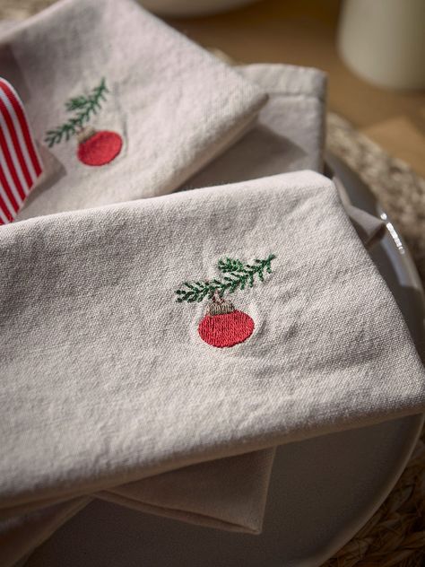 Crafted from cotton, our embroidered bauble napkins are the perfect combination of Christmas décor with a subdued and minimalist feeling.        With a simple embroidered bauble on the right hand side, the neutral background complements the minimal design creating a napkin that will blend into any dining setting seamlessly.       A matching table runner is also available.        Explore the rest of our Regency Romance collection. Embroidered Napkins Christmas, Simple Embroidery Christmas, Christmas Embroidery Napkins, Christmas Napkins Embroidery, Embroidered Christmas Napkins, Christmas Embroidery Simple, Simple Christmas Embroidery, Napkin Embroidery, Hand Embroidered Napkins