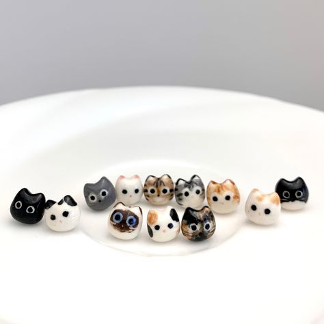 "Adorable little porcelain stud earrings made to look like your favorite cats! There are 12 cat styles plus red heart.  Also Mismatched pair available: 1. White + Orange Spot 2. White + Black Spot 3. Tuxedo  4. Calico 5. Brown Tabby 6. Grey Tabby 7. Orange Tabby 8. Black 9. White 10. Grey 11. Tortoiseshell  12. Siamese 13. Red Heart 14. Mismatched Pair* *If you would like a \"Mismatched Pair\" please specify the combination at the checkout. Dimensions Each stud is about 5/16\" (0.8cm) in diamete Cat Stud Earrings, Brown Tabby, Tiny Cats, Cat Earrings Studs, Tanah Liat, Orange Tabby, Porcelain Jewelry, Cute Clay, Porcelain Clay