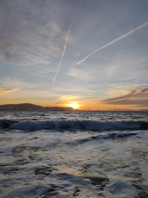 The sun is rising over the waves at Keem Beach with a mountain in the background. Moodboard Travel, Ireland Summer, Achill Island, Mayo Ireland, Ashford Castle, County Mayo, February 2023, Summer 24, Travel Photos