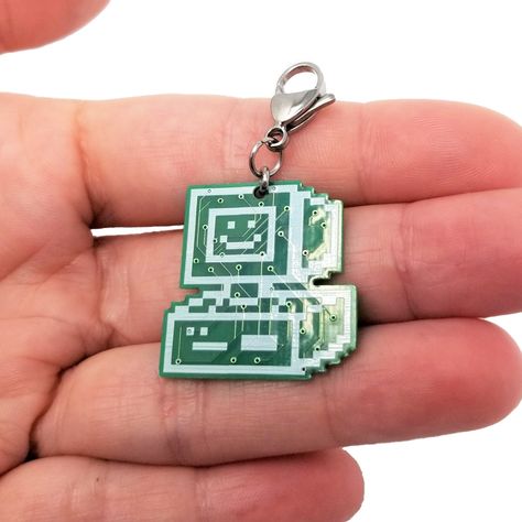 This listing is for a Happy Computer pixel art charm by Happy Hardwear. The charm is made of genuine lead-free circuit board connected to a sturdy but lightweight stainless steel lobster clasp. These charms are lightweight, durable and comfortable for wearing day and night. - Includes one Happy Computer charm - Charm color: Green with White Silkscreen - Charm size: 27mm x 27mm, 1mm thickness - Clasp style: Lobster claw - Material: Lead-Free Circuit Board with Copper Traces, Stainless Steel clasp Gifts For Tech Guys, Funky Keychains, Pixel Art Keychain, Robot Keychain, Circuit Board Clothes, Weirdcore Keychain, Circuit Board Accessories, Computer Circuit Board, Tech Gifts For Men