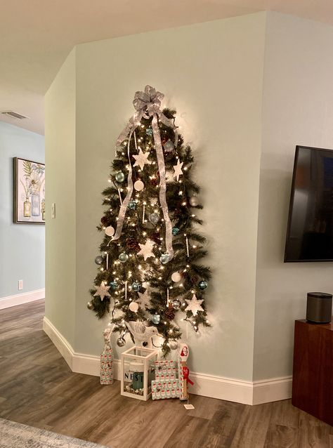 Wall Christmas Tree- when you don’t have room for a full tree! Fold two strings of garland in half and flatten the branches on one side. Hang both on the wall on command hooks - one a few inches lower than the other. Secure the 4 end pieces to the wall with non damaging tape. Decorate as usual. Diy Wall Christmas Tree, Small Space Christmas Tree, Wall Mounted Christmas Tree, Christmas Tree Gif, Half Christmas Tree, Half Christmas, Wall Hanging Christmas Tree, Christmas Tree Clear Lights, Christmas Tree With Lights