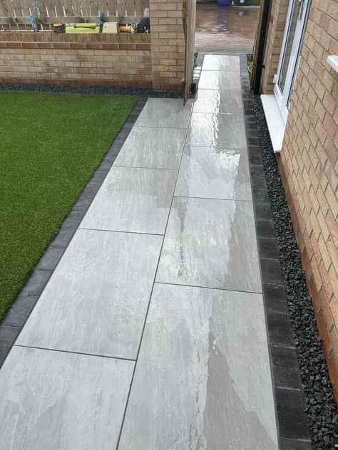 A beautifully modern patio whilst using a more traditional look paving. Aged Kandla Grey porcelain gives you the look of natural stone, but with porcelain low maintenance. 📞Call our team on 01977 782240 💻Visit the product on our website https://rflandscapeproducts.co.uk/product/aged-kandla-grey-2cm-porcelain-paving/ Details ✔️ Product : Aged Kandla Grey Porcelain Format - 600x900x2cm Material - Porcelain Available in drainage, copings and bullnosed steps. ✔️Trade accounts available ... Patio Paving, Grey Paved Driveway, Porcelain Patio, Grey Patio Paving, Grey Paving Slabs Ideas Patio, Grey Porcelain Patio, Grey Driveway Block Paving, Grey Porcelain Paving, Grey Patio