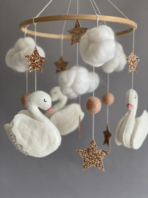 Swans felt baby mobile is perfect decoration for a baby girl or boy nursery room. It will surely become a perfect design item in your kid's room. Our mobiles are made with high quality, ecological materials. It is completely handmade work which made with great love for your little ones. A gentle mobile will decorate your nursery room and contribute to the development of the baby.● ● Felt baby mobile includes: 3 swans 4 clouds 3 felt balls8 stars ● ● You can choose any color according to your roo Baby Mobile Ideas, Floral Nursery Theme, Felt Mobiles, Swan Nursery Decor, Ballet Nursery, Swan Nursery, Unicorn Mobile, Stars Baby Mobile, Nursery Bassinet