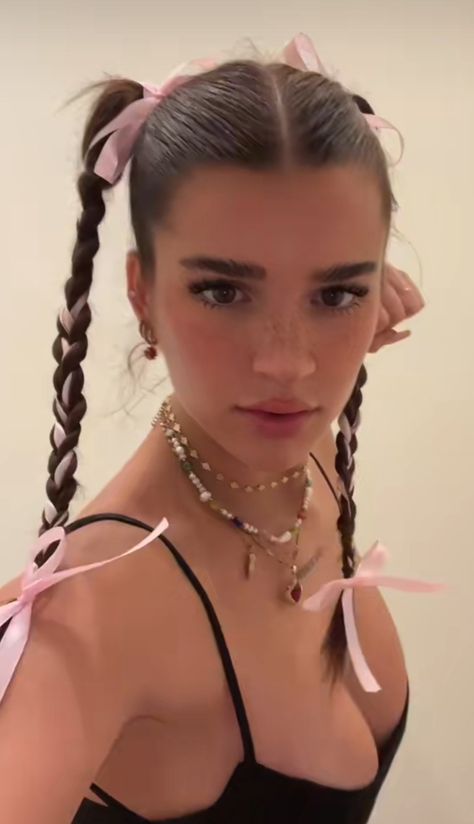 Girl with pink ribbons weaved into two braids and wearing layered pearl jewelry. Y2k Inspired Hairstyles For Long Hair, Bela Hadid Hairstyle, Nyc Hairstyles Street Style, Hair Styles With A Ribbon, Gracie Abrams Ribbon Hair, Hair Inspo Ribbon, Jell Hairstyles, Hair Styles Aesthetic 90s, Hairstyles W Ribbon