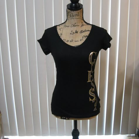 Nwt Guess Black Tee T Shirt T-Shirt Top Size Xs Extra Small. Sexy V-Neck. Has Rhinestone Studded Metallic Rose Gold Logo Graphic Down The Left Side. 100% Cotton. Brand New, Never Worn. Original Price: $22.99 More Colors Available See My Other Listings! Y2k Emo Shirts, 90s Shirts Graphic Tees, Poshmark Clothes, Rose Gold Logo, Guess Shirt, White Short Sleeve Shirt, Black Short Sleeve Shirt, Metallic Rose Gold, Lace Tshirt