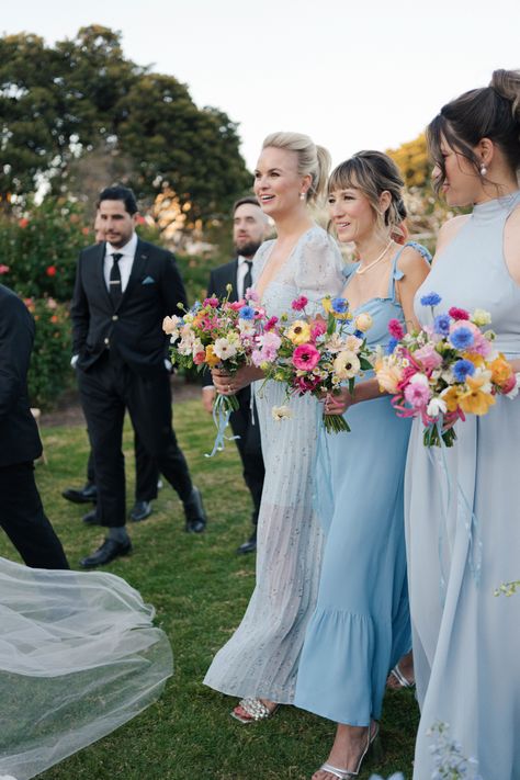 Kelsey & William's wedding at the Natural History Museum. Her bridesmaids were her "something blue" with their wildflower-inspired bouquets by Tularosa Flowers Blue Bridesmaid Dresses Bright Flowers, Dusty Blue Wedding With Wildflowers, Colorful Lake Wedding, Blue And Wildflower Wedding, Ice Blue Bridal Party, Wildflower Wedding Bridesmaid Dresses, Blue Bridesmaids Colorful Flowers, Wildflower Bridesmaids Bouquet, Bridesmaids With Colorful Bouquets