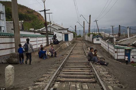 Locals sit with their children beside train tracks in a dilapidated part of Wonsan, North Korea  Read more: http://www.dailymail.co.uk/news/article-2805410/Unseen-North-Korea-captured-American-photographers.html Inside North Korea, Life In North Korea, Tourist Sites, Korea Travel, North Korean, A Town, North Korea, Rare Photos, Capital City