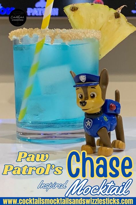 This image shows a blue zero proof drink with a brown sugar rim, pineapple wedge garnish and yellow striped straw with Chase from the paw patrol in front of it. Mocktail For Kids, Cruise Cocktails, Disney Inspired Cocktails, Movie Dinner, Birthday Party Drinks, Paw Patrol Movie, Movie Night Dinner, Disney Dinner, Chase Paw Patrol